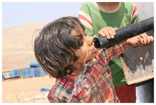 Drinking from a portable water tank in Al Hadidiya